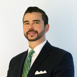 CEO Ryan J. Woods headshot in suit and striped green tie